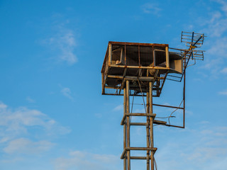 Old public loudspeakers broadcast vintage style on high tower the blue sky background