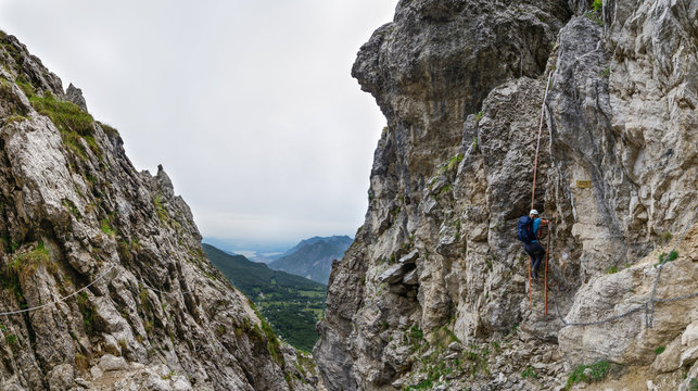 Woman climbing a ladder on the Via Ferrata at the Grigna Settentrionale (2408 m, Grignetta), Lake Como, Italy