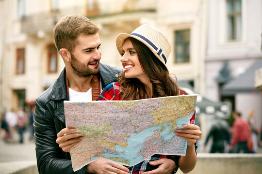 Tourist Couple In Love Traveling In City With Map.