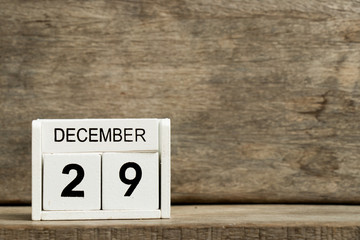 White block calendar present date 29 and month December on wood background
