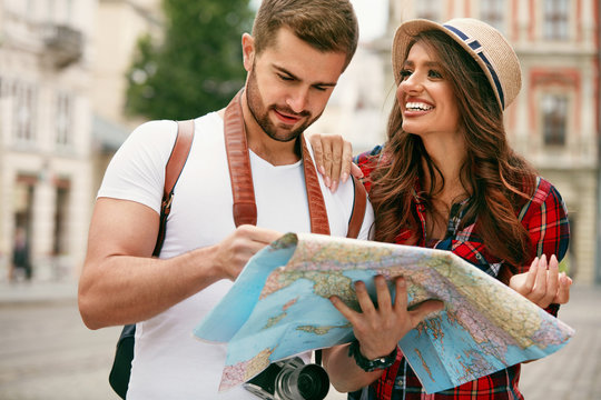Happy Tourists. Beautiful Couple Sightseeing With Map.