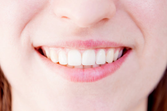Close-up of healthy white teeth of smiling woman female. Body part - mouth.