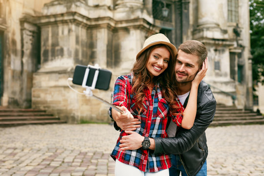Lovely Tourist Couple Taking Photos On Phone On Street