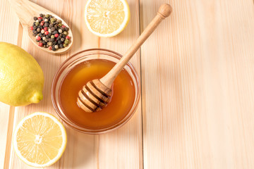 Honey with lemon and spice on a wooden background.