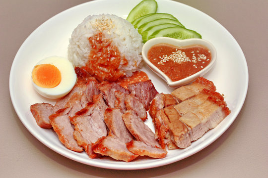 Jasmine rice with meat and boiled egg topped red sweet sauce .