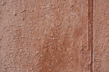 An old cracked brown paint on a wooden door