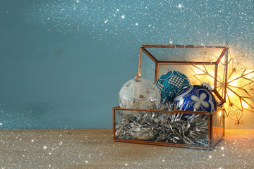 Image of christmas festive decorations in the vintage glass box on wooden table.