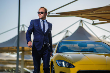 Successful yang businessman in yellow cabrio car in Dubai.