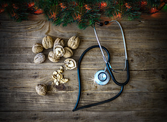 Stethoscope and walnuts on an wooden background with christmas decor. A medical, healthcare and wellness concept