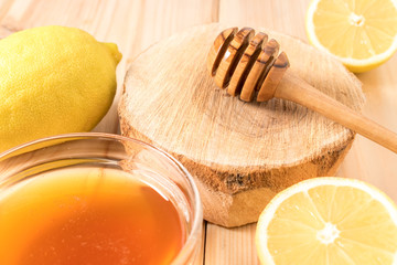 Honey with lemon on wooden background.