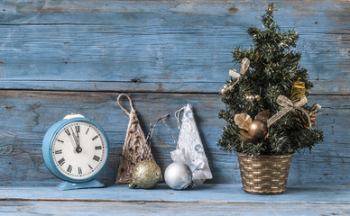 Christmas decoration and alarm clock on wooden background