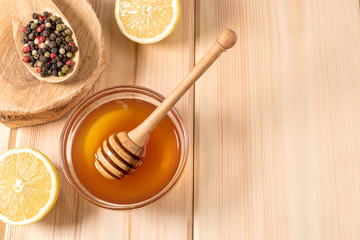 Honey with lemon and spice on a wooden background.