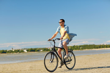 Fototapeta premium happy man riding bicycle along summer beach