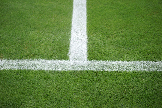 Seitenlinie Fußballfeld  / Die grüne Rasenfläche eines Fußballfeldes mit der Seitenlinie und der Mittellinie.