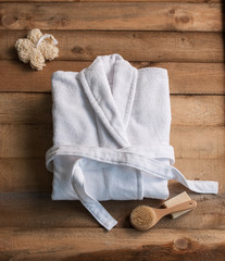 bathrobe bath soap and loofah brush on the wooden background
