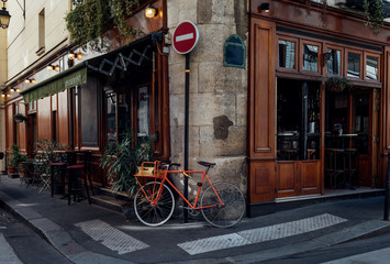 Cozy street with tables of cafe and old bicycle in Paris, France