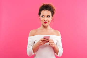 Portrait of a smiling playful girl holding mobile phone