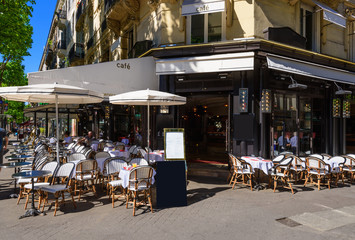 Typical view of the Parisian boulevard with tables of brasserie (cafe) in Paris, France
