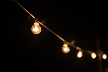 Light bulb on brick wall background switched on.