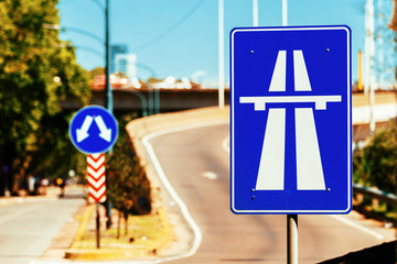 Blue sign of entrance to a freeway with empty ramp