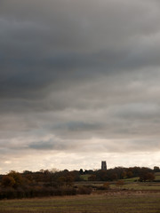 dramatic sky over open empty grassland plain special with church spire tower