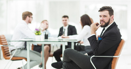 Manager of the company on the background of the working meeting the business team