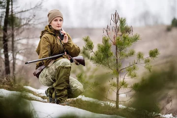 Papier Peint photo Lavable Chasser female hunter ready to hunt, holding laser finder in forest. hunting and people concept