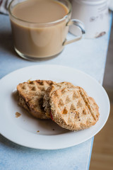 Grilled cheese wholegrain sandwich with tomato and cup of coffee with milk on light table background. Morninig concept