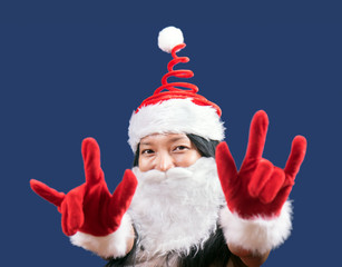 Mrs. Claus shows the gesture of the horns. Cheerful Mrs Claus makes a gesture symbol of the demons.