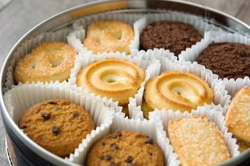 Assorted butter cookies in box on wooden table