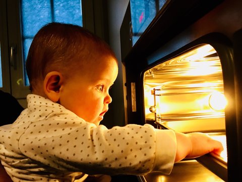 Baby staunt vor Ofen