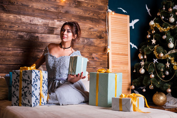 Young beautiful girl in the anticipation of the new year and Christmas in festive clothes
