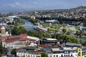 Fototapeta premium Kingdom of Georgia, Tbilisi (Tiflis): Skyline with red roofs of the Georgian capital with river, houses, churches and horizon in the background. 