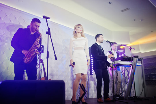 Musicial music live band performing on a stage with different lights.