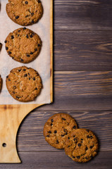 Homemade oatmeal cookies on a wooden cutting Board. Wooden background. Vertical photo