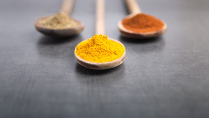 various spices in wooden spoons