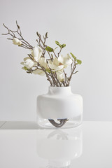 white vase of flowers glass vase on the white table and white wall