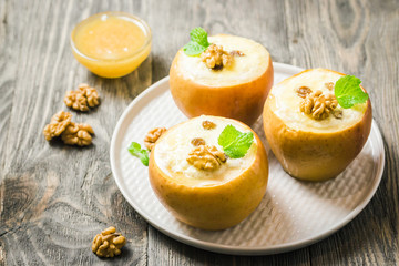 Healthy dessert cream cheese stuffed baked apples on rustic wooden background. Selective focus, space for text. 