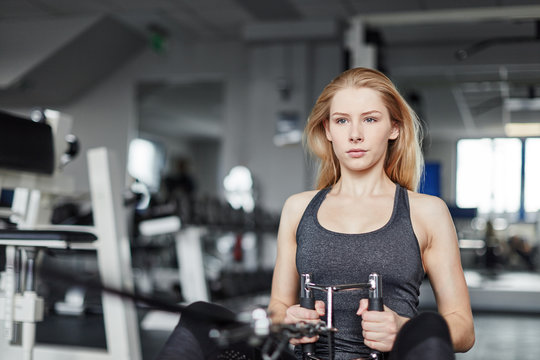 Junge Frau beim Workout am Ruderger&auml;t