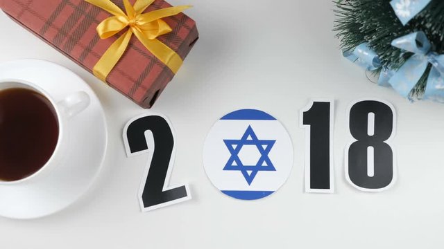 Illustration, new year, male hand put on the table an Israel flag, cauntry ball, 2018