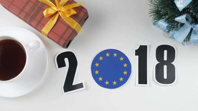 Illustration, new year, male hand put on the table an European Union flag, cauntry ball, 2018