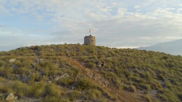 Old Watchtower with a Spanish Flag and Rolling Landscape Reveal