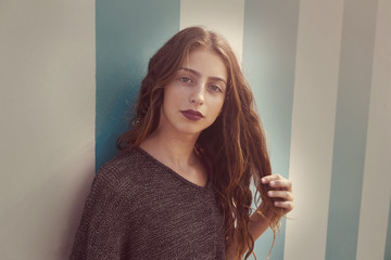 Brunette teen girl portrait in blue stripes wall