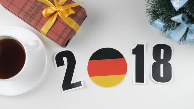Illustration, new year, male hand put on the table an German flag, cauntry ball, 2018
