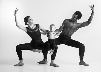 A happy family of ballet dancers on white studio background