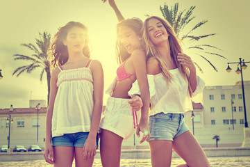 Best friends teen girls fun in a beach sunset