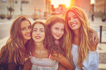 Best friends teen girls at sunset in the city