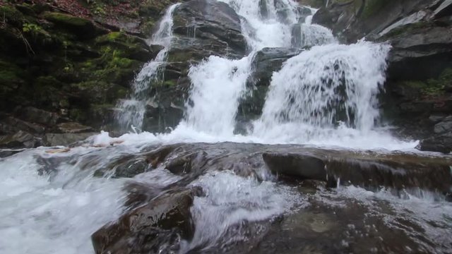 Powerful stream of Whimper Waterfall in Carpathians (Ukraine) with low angle above the water (1080p, 25fps, sound)