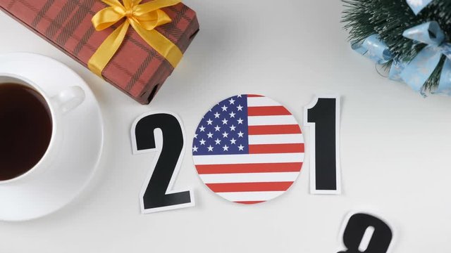 Illustration, new year, male hand changes the year from 2017 to 2018, United States of America flag, cauntry ball.
