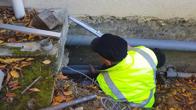 The plumber man checks the slope of the drain pipes in the foundation of the house.